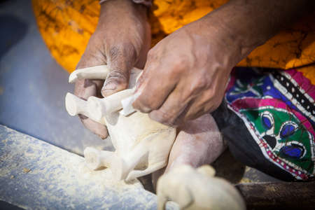 A person's hands, manufacturing an elephant figurine.の写真素材