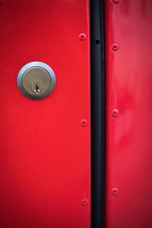 Close up image of a key hole on a red background.の写真素材