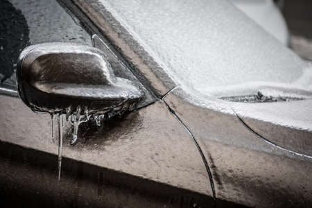 Close up shot of a frozen car mirror after freezing rain.