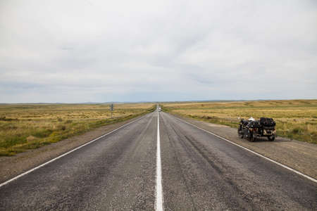 A sidecar motorcycle on an empty stretch of road.の写真素材