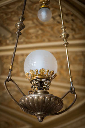 Color image of an old chandelier hanging from the ceiling, illuminated.の写真素材
