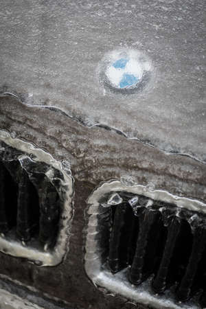 Bucharest, Romania - January 27, 2019: Illustrative-editorial image of a BMW logo is displayed on a car's hood, covered by ice. BMW is a German car manufacturer.のeditorial素材