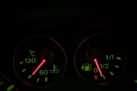 Close up shot of a car's coolant temperature and fuel gauge.