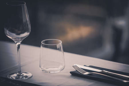 Empty glasses and dish ware on a table in a restaurant.の写真素材