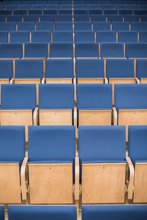 Image of rows of empty blue seats in a conference room.の写真素材