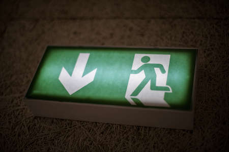 Color image of a green exit sign above a door.