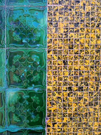 Close up shot of a wall decorated with tiles of various models.