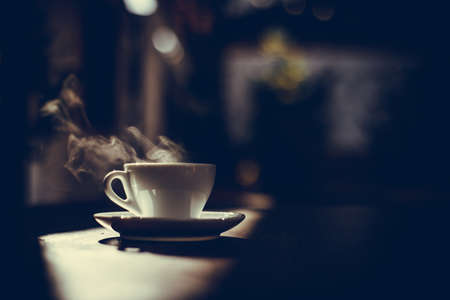 Image of a steamy coffee cup in the sunlight, with shallow depth of field.の写真素材