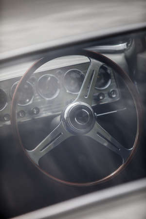 Color close up of the wooden steering wheel of an old classic car.