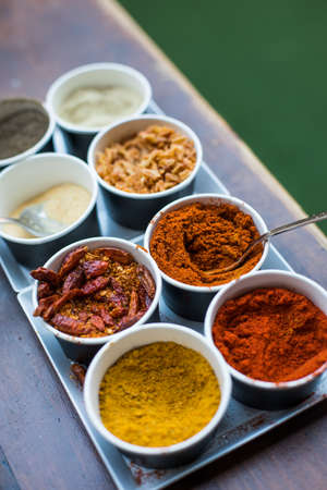 Close up shot of various colored spices in recipients.の写真素材