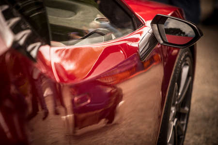 Close up shot of a red car's side mirror.