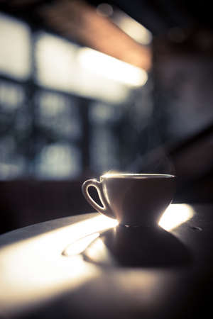 Image of a steamy coffee cup in the sunlight, with shallow depth of field.の写真素材