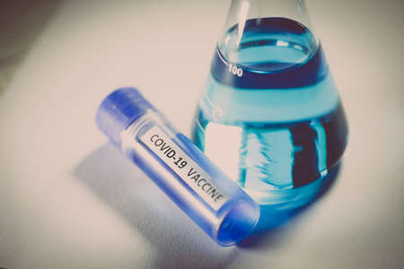 Conceptual image of a recipient containing a vaccine for coronavirus COVID-19, in a lab.