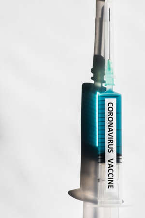 Conceptual image of a syringe containing a vaccine for coronavirus COVID-19, in a lab.の写真素材