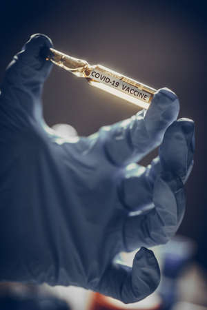 Conceptual image of a nurse holding a recipient with the coronavirus COVID-19 vaccine.の写真素材