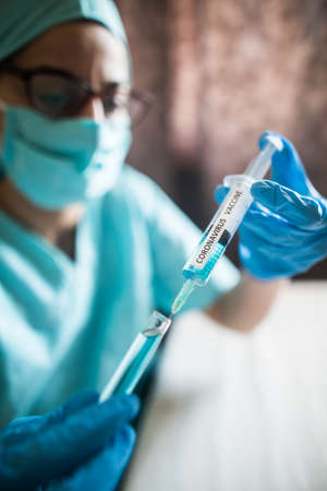 Conceptual image of a nurse holding a syringe with the coronavirus COVID-19 vaccine.の写真素材