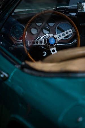 Color close up of the wooden steering wheel of an old classic car.