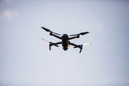 Color image of a drone flying at sunrise.