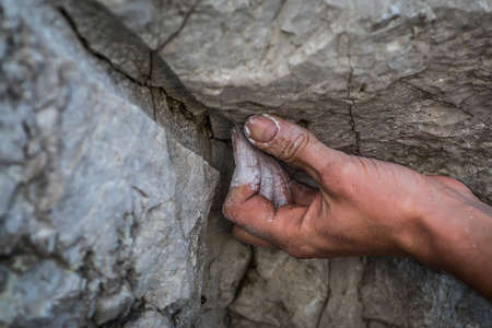 Close up shot of an adult male handholding on to a rock, illustration for rock climbing.の写真素材