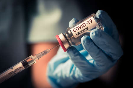 Image of a female doctor holding a COVID-19 vaccine, illustration for the new coronavirus pandemic.の写真素材
