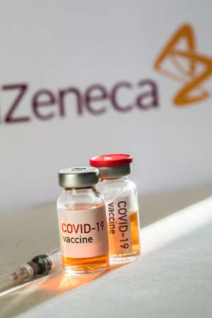 Bucharest, ROMANIA - February 10, 2021: Illustrative editorial concept image with a dose of the new Coronavirus COVID-19 vaccine, with the AstraZeneca logo in the background.のeditorial素材