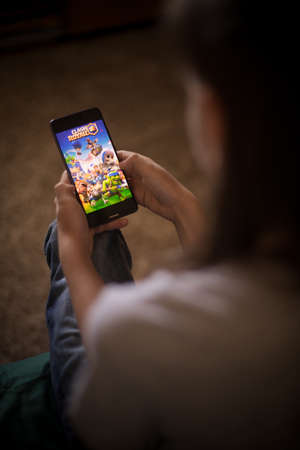 Bucharest, ROMANIA - May 10, 2021: Illustrative editorial concept image of a child playing Clash Royale game on a mobile phone.のeditorial素材
