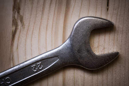 Close up shot of a metal wrench on a wooden background.の写真素材