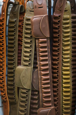 Old cartridge belts displayed in a hunting shop.の写真素材