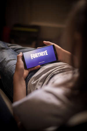 Bucharest, ROMANIA - May 10, 2021: Illustrative editorial concept image of a child playing Fortnite game on a mobile phone. Fortnite is a multiplayer Battle Royale shooter game by Epic Games.のeditorial素材