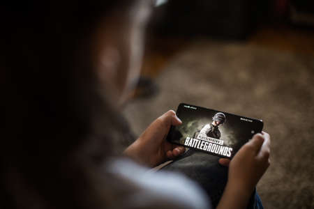 Bucharest, ROMANIA - May 10, 2021: Illustrative editorial concept image of a child playing Battlefields game on a mobile phone.のeditorial素材