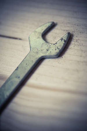 Close up shot of a metal wrench on a wooden background.の写真素材