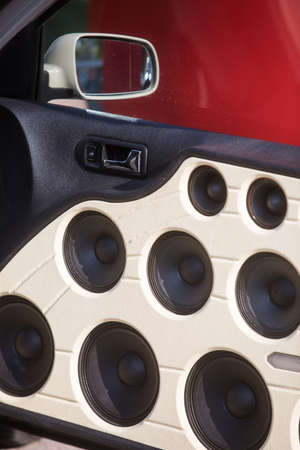 The inside of a car door full of stereo speakers.