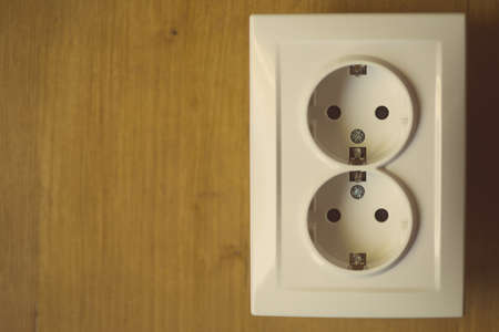 Close up shot of an electric socket on a wooden background.の写真素材