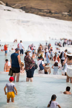 Pamukkale, TURKEY - July 24, 2021: Image of the travertin terraces in Pamukkale, Turkey and tourists walking by.のeditorial素材