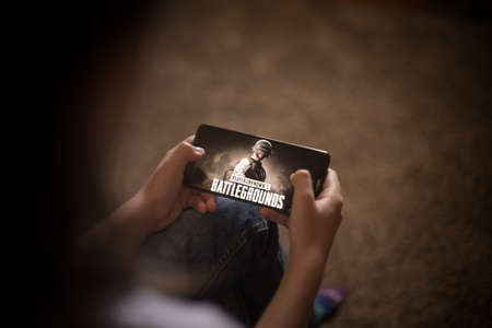 Bucharest, ROMANIA - May 10, 2021: Illustrative editorial concept image of a child playing Battlefields game on a mobile phone.のeditorial素材