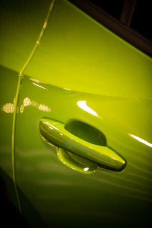 Close up shot of a modern door handle of a green car.の写真素材