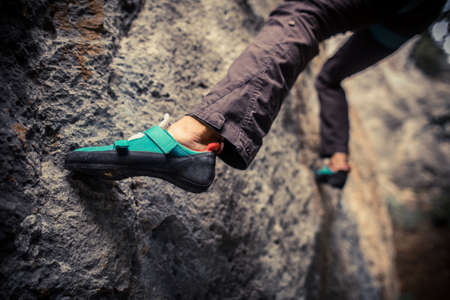 Close up shot o a person climbing while wearing rock climbing shoes.の写真素材