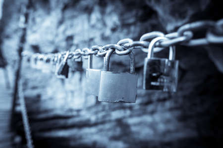 Close up shot of many padlocks on a chain, metaphor for a love relationship.の写真素材