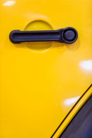 Close up shot of a modern door handle of a yellow car.の写真素材