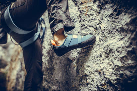 Close up shot o a person climbing while wearing rock climbing shoes.の写真素材