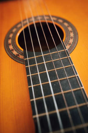 Close up shot of a wooden classical guitar, with plastic strings.の写真素材