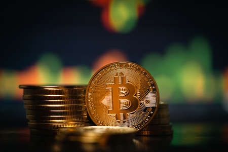 Stack or heap of gold Bitcoins cryptocurrency with candle stick graph chart and digital background.