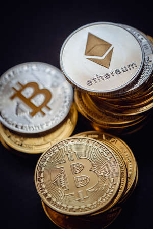 Close up shot of stacks of golden and silver Bitcoin and Ethereum digital cryptocurrency.