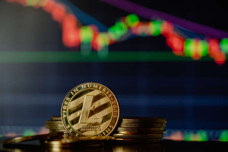 Stack or heap of gold Litecoin cryptocurrency with candle stick graph chart and digital background.の写真素材