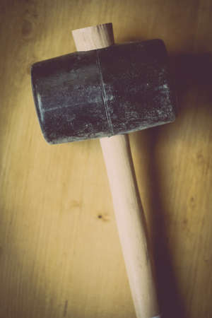 Close up shot of a big rubber hammer on a wooden background.の写真素材