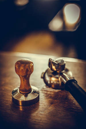 Close up shot of a tamper and portafilter, used in making espresso coffee.