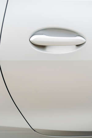 Close up shot of a modern door handle of a white car.の写真素材