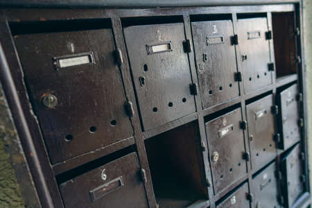 Many wooden post boxes in old apartment building.の写真素材
