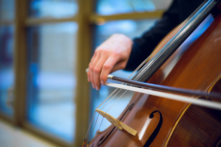 Detail view of an unrecognizable man playing the cello in public.