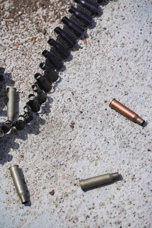 Machine gun empty bullet cartridges lay on the ground after being fired.